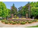Landscaped community entrance with stone features, colorful flowerbeds, and American and North Carolina flags at 12746 Bravington Rd, Huntersville, NC 28078