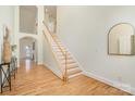 Bright entryway showcasing hardwood floors and a staircase with white railing at 130 Hopedale Ct, Mooresville, NC 28117
