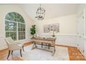 Inviting home office featuring a large window, decorative wainscoting, and hardwood floors at 130 Hopedale Ct, Mooresville, NC 28117