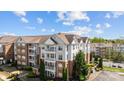Beautiful condo community with brick and siding exteriors, balconies, lush landscaping, and blue skies at 14869 Santa Lucia Dr, Charlotte, NC 28277
