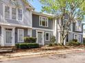 Street view of townhomes showcases gray siding, white trim, and lush landscaping, enhancing neighborhood charm at 1568 Cleveland Ave, Charlotte, NC 28203