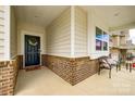 Covered front porch with brick detailing, neutral siding, and a welcoming front door with wreath at 1588 Trentwood Dr, Fort Mill, SC 29715