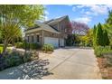 Spacious driveway leading to a three-car garage, surrounded by lush landscaping and mature trees at 16636 Flintrock Falls Ln, Charlotte, NC 28278