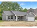 Inviting single-story home with gray siding, stone veneer accents, and a two-car garage for modern comfort at 1706 30Th Avenue Ne Ct, Hickory, NC 28601