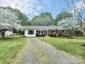 Quaint single-story brick home with a driveway, well-manicured lawn, and mature trees at 171 Westmoreland Rd, Mooresville, NC 28115