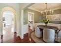 Inviting dining room featuring a stylish chandelier and beautiful hardwood floors with views into the kitchen and hallway at 1824 Hall Ave, Charlotte, NC 28205