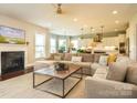 Cozy living room with a fireplace, plush sofa, and large windows at 18721 Dumbarton Oaks Dr, Cornelius, NC 28031