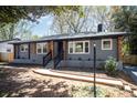 Charming gray brick home featuring a welcoming front porch and well-maintained landscaping at 2014 Sandhurst Dr, Charlotte, NC 28205