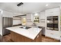 Modern kitchen with stainless steel appliances, island cooktop, and sleek white cabinetry at 2014 Sandhurst Dr, Charlotte, NC 28205