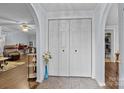 Welcoming foyer features arched doorways, neutral paint, tiled floor, and coat closet with folding doors at 335 Ridgewood Dr, Mt Ulla, NC 28125