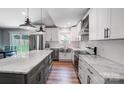 Beautiful white kitchen featuring an island with a gray base, stainless appliances, and marble countertops at 3612 Cobbleridge Dr, Charlotte, NC 28215