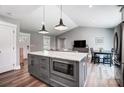 Open-concept kitchen with gray island, marble countertops, and seamless transition to the living area at 3612 Cobbleridge Dr, Charlotte, NC 28215