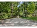 Long driveway leading to a private estate, surrounded by mature trees and lush landscaping at 3819 Gleneagles Rd, Charlotte, NC 28210