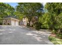 Brick exterior home with a circular driveway and multiple garage spaces surrounded by trees at 3819 Gleneagles Rd, Charlotte, NC 28210