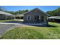 Quaint single-story home featuring a covered parking area and a well-manicured lawn at 427 W Whitley St, Norwood, NC 28128