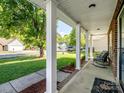 Inviting covered porch with white columns, brick accents, and a relaxing seating area at 4665 Madeline Dr, Rock Hill, SC 29732