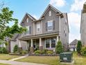 Attractive two-story home featuring a covered porch and manicured lawn at 6433 Raffia Rd, Charlotte, NC 28277