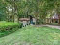 A view of the front of the house on a large manicured lot surrounded by mature trees at 6745 Thermal Rd, Charlotte, NC 28211