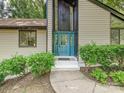 A close up of the front door, which is blue, and surrounded by bushes and windows at 6745 Thermal Rd, Charlotte, NC 28211