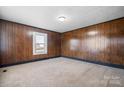Bright living room showcasing wood paneling, neutral carpet and ample natural light at 71 14Th Se St, Hickory, NC 28602