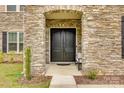 Close-up of a solid double front door framed by stone, creating an inviting and secure entrance at 7157 Sumters Camp Trl, Indian Land, SC 29707