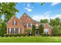 Charming brick home with a well-maintained lawn and manicured landscaping, including trimmed bushes at 7302 Yellowhorn Trl, Waxhaw, NC 28173