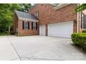 Spacious three-car garage with a wide concrete driveway and brick siding, offering ample parking at 7302 Yellowhorn Trl, Waxhaw, NC 28173