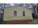 This yellow home features a brick foundation, and two windows on the side at 828 Williams St, Gastonia, NC 28052