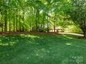 Expansive lawn surrounded by mature trees, offering a serene and private outdoor space for relaxation or recreation at 9101 Oak Bluff Ct, Marvin, NC 28173