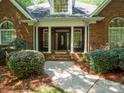 Covered porch with rocking chairs and a decorative front door with sidelights enhance the curb appeal of this brick home at 9101 Oak Bluff Ct, Marvin, NC 28173