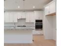 Bright kitchen features white cabinetry, stainless appliances, and a center island at Tbd Boomer Ct # 1, Statesville, NC 28677