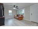 Bright living room featuring a brown leather sofa, neutral walls, and luxury vinyl plank flooring at 103 Moore Ave, Mount Holly, NC 28120