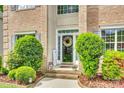 Inviting front entrance with a wreath on the door, decorative plants, and cheerful welcome sign at 14818 Hawick Manor Ln, Pineville, NC 28134
