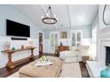 Airy living space featuring a fireplace, shiplap walls, modern lighting, and hardwood floors at 200 Port Royal Dr, Matthews, NC 28105