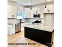 Bright kitchen with white cabinets, granite countertops, stainless appliances, and kitchen island at 210 Carolina Dr # 1000&999, Troy, NC 27371
