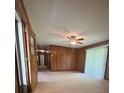 Cozy living room featuring wood paneled walls, a ceiling fan, and abundant natural light at 215 Suncrest Rd, Cherryville, NC 28021