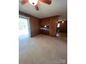Open-concept living area offering carpet floors, ceiling fan, and access to outdoor space through sliding glass doors at 215 Suncrest Rd, Cherryville, NC 28021