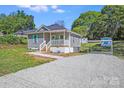 Charming single-story home with a small front porch, gray siding and a driveway leading to a carport at 221 River Loop Rd, Belmont, NC 28012