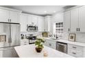 Bright kitchen featuring white cabinets, stainless steel appliances, marble countertops, and modern fixtures at 221 River Loop Rd, Belmont, NC 28012