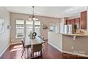 Bright dining area with hardwood floors and modern lighting fixture, adjacent to the kitchen at 2268 Kensington Station Pkwy, Charlotte, NC 28210