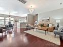 Spacious living room featuring hardwood floors, a stylish chandelier, and comfortable seating at 2268 Kensington Station Pkwy, Charlotte, NC 28210