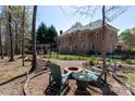 Spacious brick home backyard with firepit seating area, garden and covered hot tub at 3010 Lakewood Edge Dr, Charlotte, NC 28269