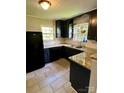 Modern kitchen featuring black cabinetry, granite countertops, and subway tile backsplash at 3507 Rogers St, Charlotte, NC 28208