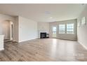 Open-concept living room featuring hardwood floors, fireplace, neutral paint, and abundant natural light at 4222 Skyboat Cir, Fort Mill, SC 29715