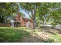 Classic brick home with mature trees, a screened porch, and a spacious front yard at 45 Mckinnon Ne Ave, Concord, NC 28025