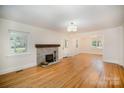 Spacious living room with hardwood floors, stone fireplace, and ample natural light at 45 Mckinnon Ne Ave, Concord, NC 28025