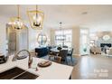 Inviting dining area with modern chandelier, table set for six, leading to the living room and kitchen at 4825 Reason Ct # 73, Harrisburg, NC 28075