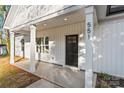 An inviting home exterior with white pillars, a sleek black front door, and modern design elements at 551 Belfast Dr, Gastonia, NC 28052