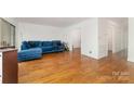Bright living room featuring hardwood floors, white walls, and a view into the entryway at 5807 Sharon Rd # A, Charlotte, NC 28210