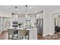 Bright kitchen featuring stainless steel appliances, pendant lighting, tile backsplash, and a center island with seating at 8105 Stillhouse Ln # 23, Harrisburg, NC 28075